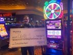 Deven holds a facsimile check for $254,212.71 at the Aliante Casino